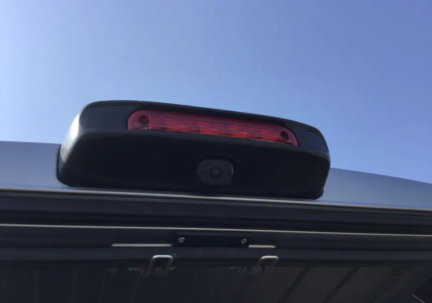 Gros plan sur le feu stop et la caméra de recul du Peugeot Boxer Fourgon gris Artense, vue arrière sous ciel bleu.