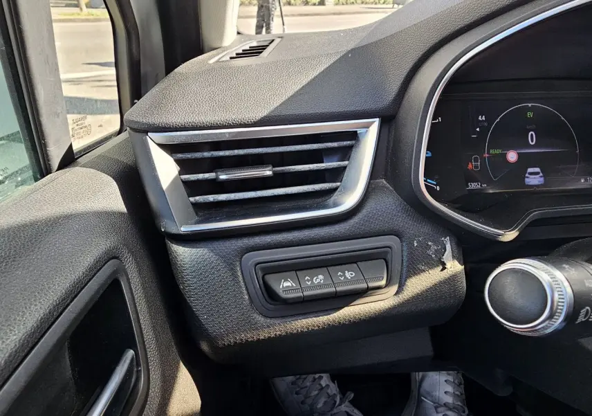 Détail du tableau de bord côté gauche de la Renault Clio blanche, avec commandes d'aide à la conduite et compteur numérique.