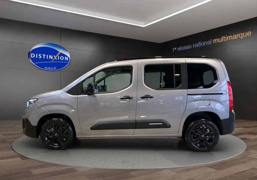 Profil latéral gauche du Citroën Berlingo gris Artense avec jantes noires brillantes en showroom.