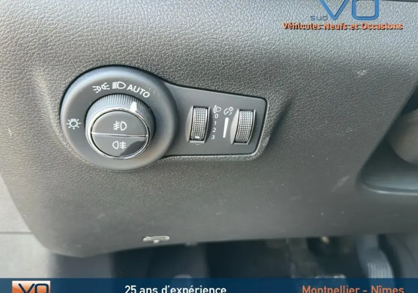 Gros plan sur le bouton de commande des phares du Jeep Compass noir 2024, montrant les réglages d'éclairage automatique.