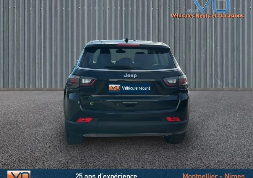 Vue arrière d'un Jeep Compass noir 2024 avec feux LED et logo Jeep bien visibles sur fond urbain.
