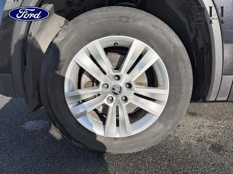 Gros plan sur la roue avant gauche avec jante alu argentée du Skoda Kodiaq noir Magic Nacré 2023