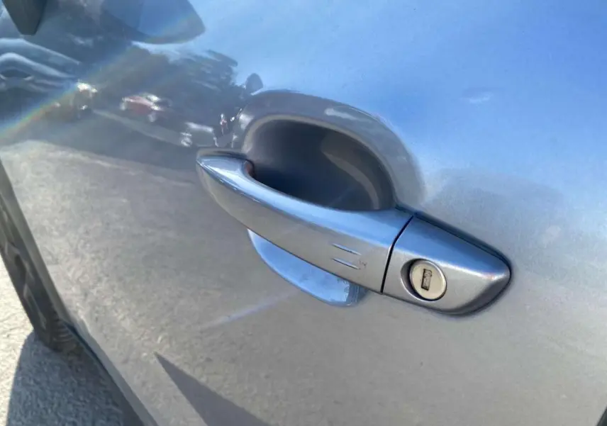 Poignée de porte côté gauche en gros plan sur Citroën C3 Aircross gris foncé 2024, finition avec serrure visible.