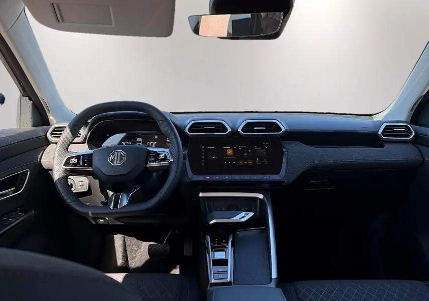 Vue intérieure avant du tableau de bord noir du MG Motor ZS 1.5 hybrid 197 avec écran tactile et volant multifonction.