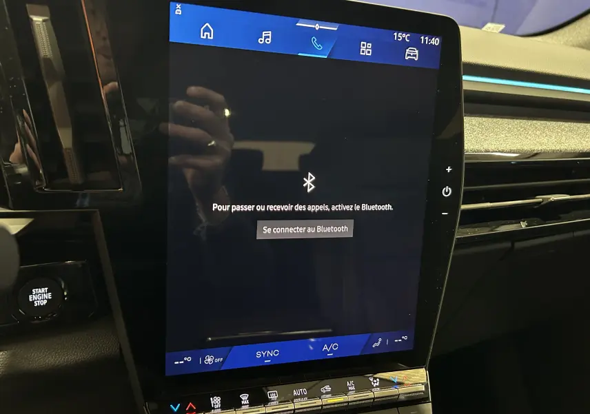 Écran tactile central allumé du tableau de bord d'un Renault Austral noir étoilé, vue rapprochée côté conducteur.
