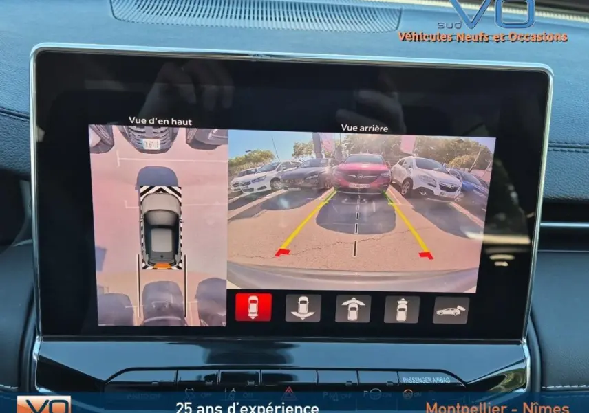 Écran tactile du Jeep Compass gris 2024 montrant la caméra de recul et la vue aérienne du stationnement.