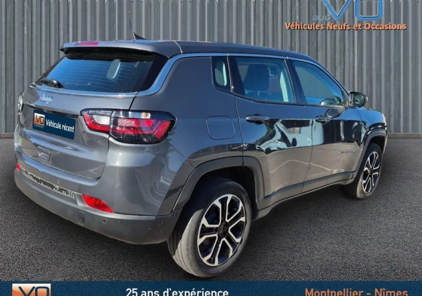 Vue 3/4 arrière droite d'un Jeep Compass gris 2024 avec jantes alliage 18 pouces et vitres teintées.