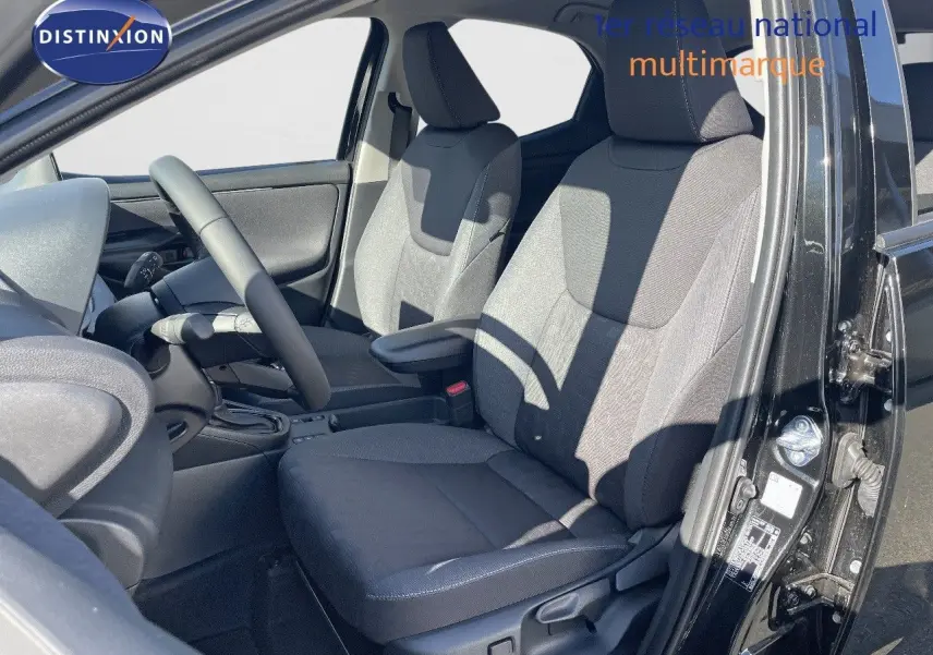 Vue intérieure côté gauche de la Toyota Yaris Hybrid 116ch noire métal, montrant les sièges avant en tissu gris.
