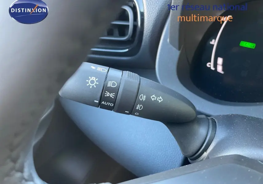 Gros plan sur la commande des feux et clignotants à gauche du volant dans le tableau de bord d'une Toyota Yaris noire 2025.