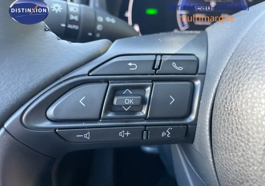 Gros plan sur les commandes multifonctions au volant d'une Toyota Yaris Hybrid 2025, finition Design noire.