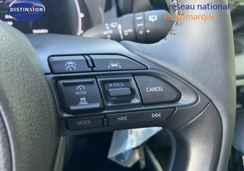 Gros plan sur les commandes au volant côté droit d'une Toyota Yaris Hybrid 2025, finition noire métal.