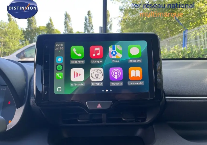 Écran tactile central affichant les applications connectées dans l'habitacle d'une Toyota Yaris Hybrid noire, vue de face.