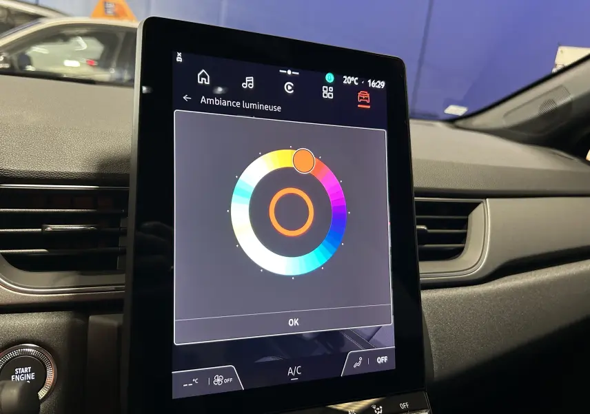 Vue intérieure du tableau de bord du Renault Captur noir étoilé 2025, écran tactile affichant l'ambiance lumineuse.