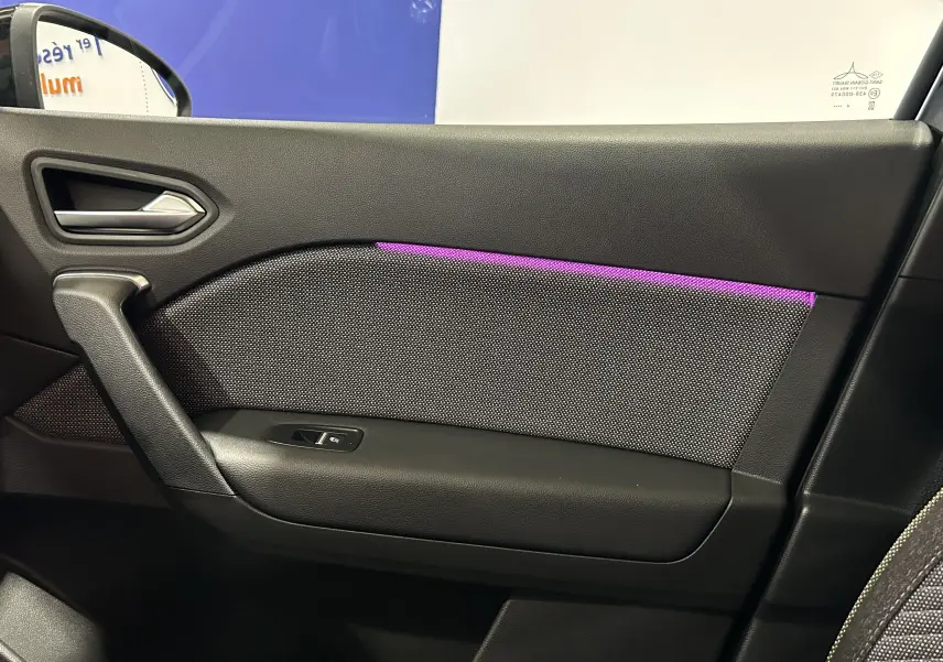 Détail de la porte côté droit du Renault Captur II Ph.2 TECHNO avec éclairage d'ambiance violet et tissu noir.
