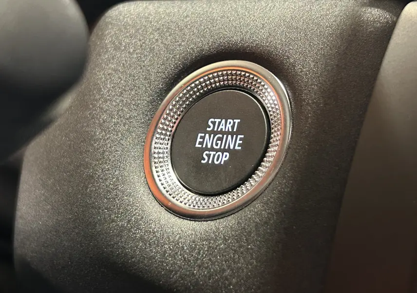 Bouton Start Engine Stop en gros plan sur tableau de bord noir du Renault Captur II Ph.2 TECHNO 2025.