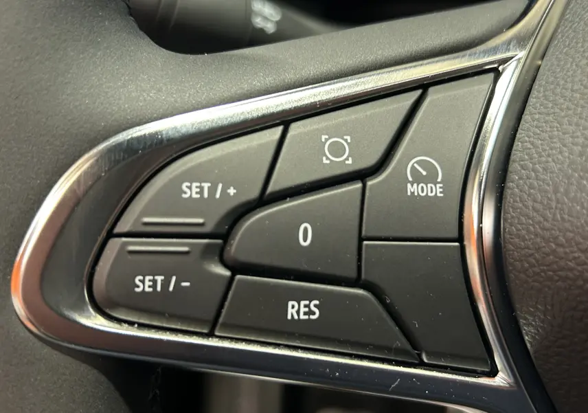 Gros plan sur les commandes de régulateur de vitesse du volant du Renault Captur II Ph.2 noir étoilé 2025.