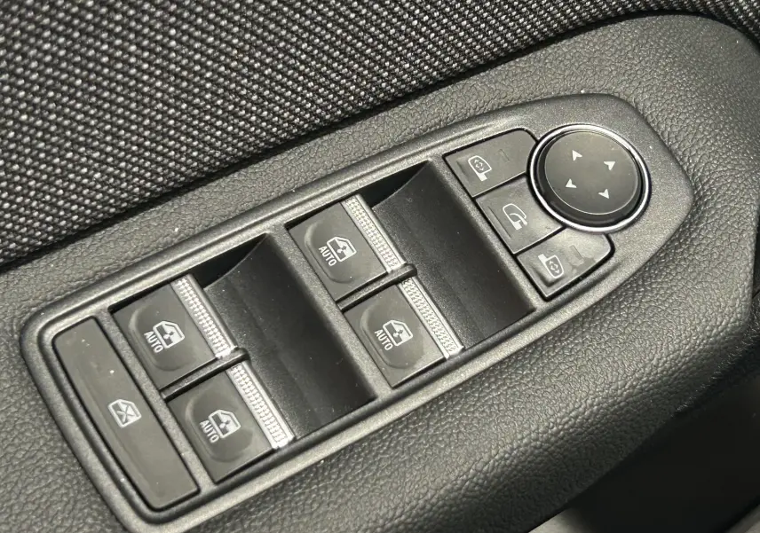 Gros plan sur les commandes de lève-vitres et réglage des rétroviseurs côté gauche du Renault Captur noir étoilé 2025.