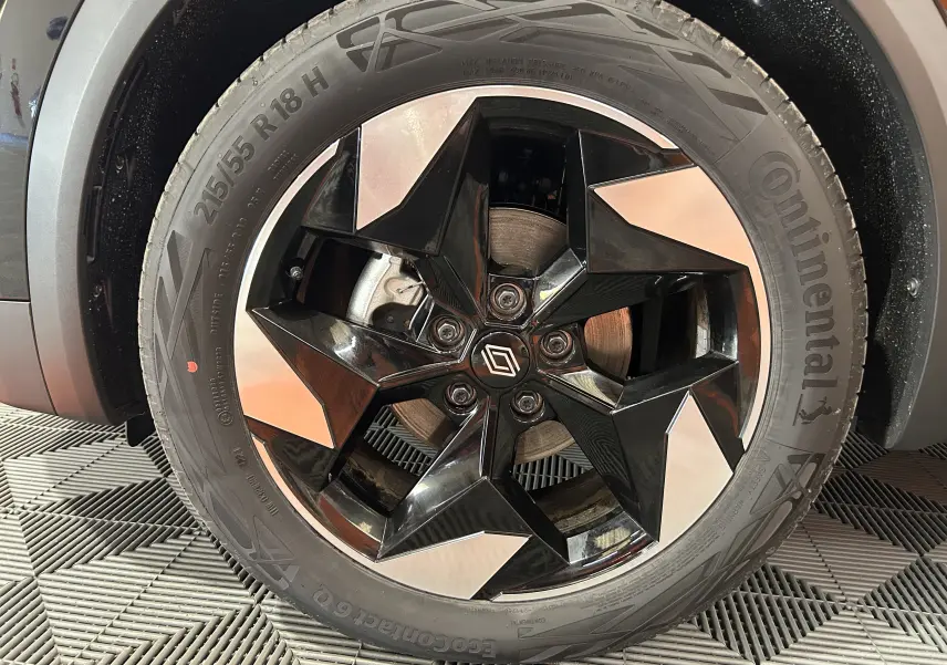 Gros plan sur la jante noire et argentée de 18 pouces d'un Renault Captur II Ph.2 TECHNO Tce 90 noir étoilé.