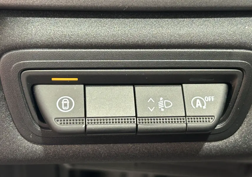 Boutons de commande noirs sur tableau de bord du Renault Captur II Ph.2 TECHNO Tce 90, avec indicateur orange allumé.