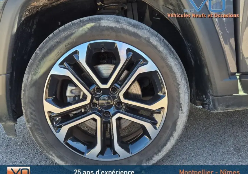 Gros plan sur la jante alliage 18 pouces noire et argent du Jeep Compass gris 2024 côté avant droit.