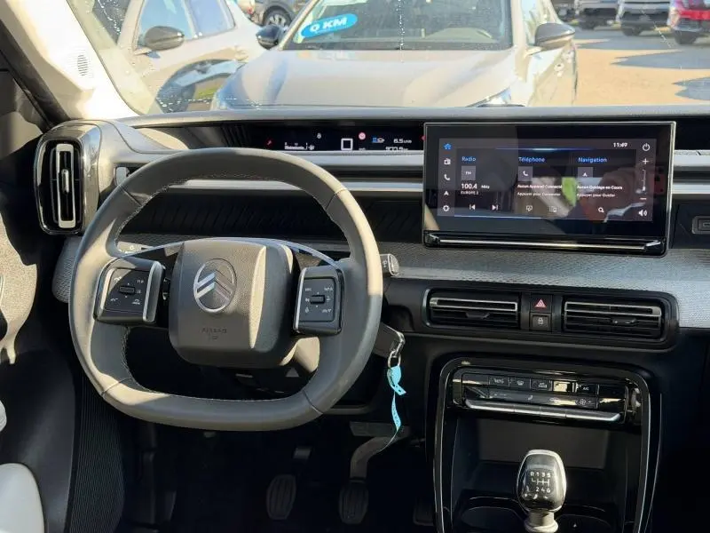 Vue intérieure du tableau de bord et volant de la Citroën C3 1.2 Turbo 100ch MAX avec écran tactile et boîte manuelle.