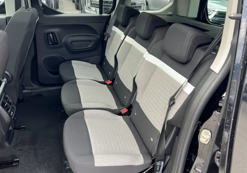 Vue latérale droite de l'intérieur arrière du Citroën Berlingo noir perla nera, sièges tissu gris clair et foncé, 3 places indépendantes.