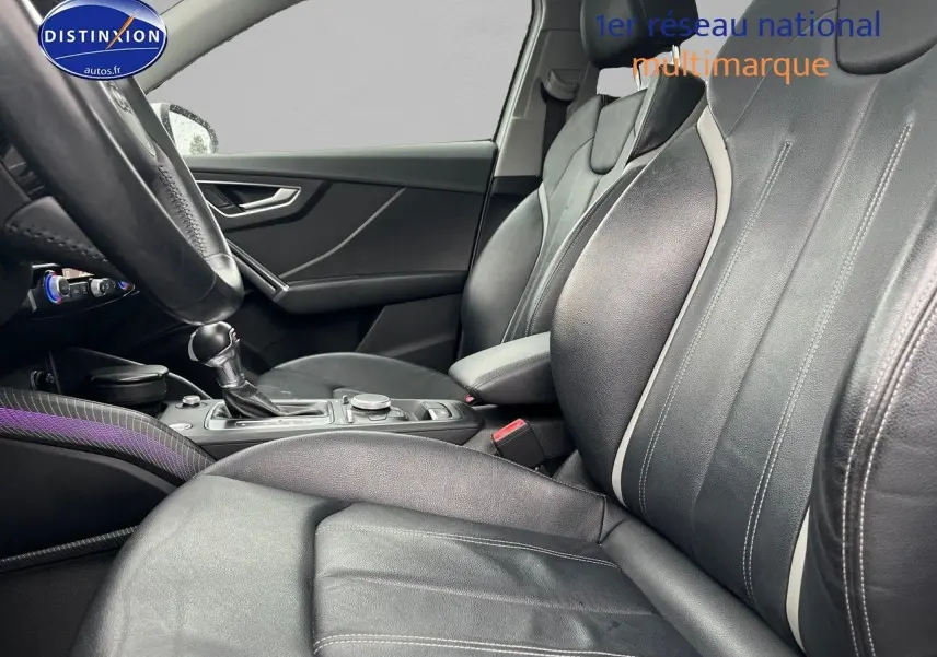 Vue intérieure côté conducteur de l'Audi Q2 2018 avec sièges cuir noir et console centrale équipée.