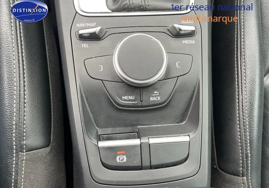 Vue rapprochée de la console centrale noire de l'Audi Q2 2018 avec commandes multimédia et frein à main électrique.