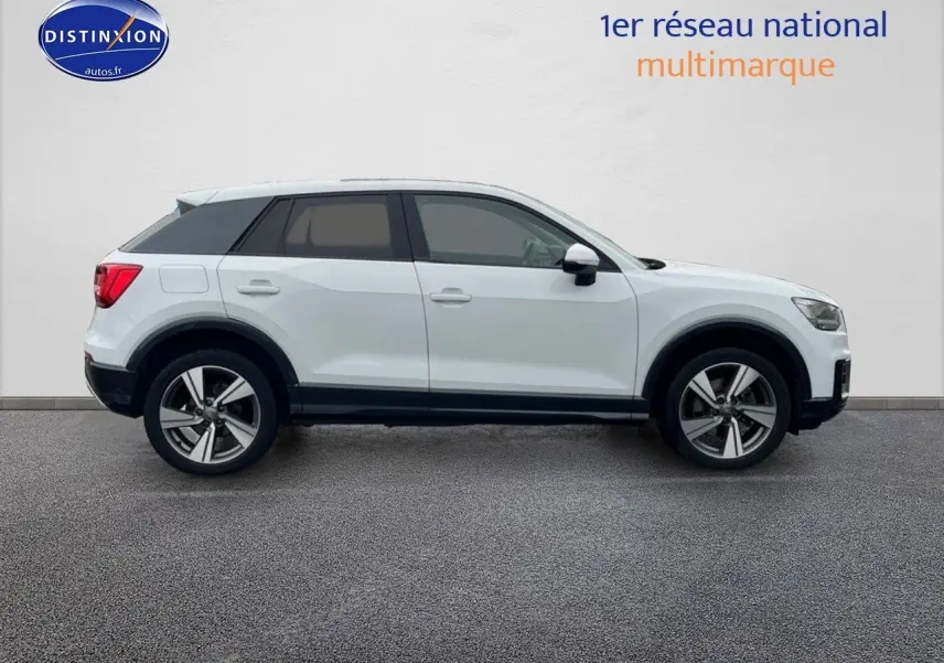 Profil droit d'un Audi Q2 blanc Ibis 2018 avec jantes 18 pouces et vitres surteintées.