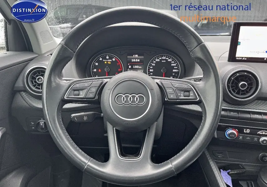 Vue centrée sur le volant en cuir noir de l'Audi Q2 2018 avec tableau de bord et écran multimédia visibles.