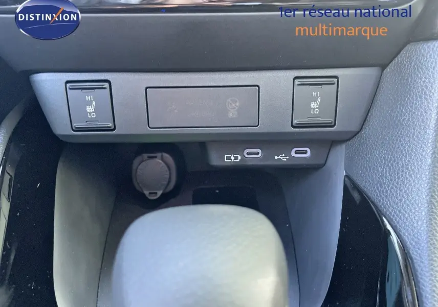 Détail de la console centrale de la Toyota Yaris Hybrid 2025 montrant les commandes de sièges chauffants et ports USB.