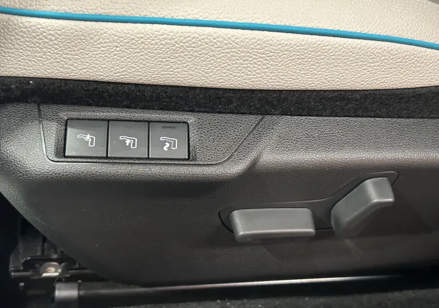 Commandes de réglage électrique des sièges sur la porte intérieure beige et bleu d'une FIAT 600 Hybrid 2024.