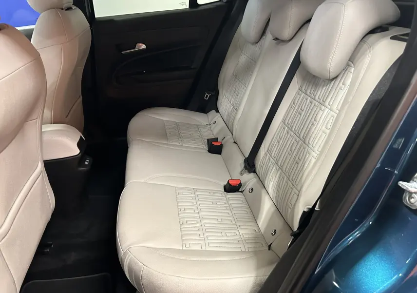 Vue intérieure du siège arrière beige clair de la FIAT 600 Hybrid 2024, avec portière bleue ouverte côté droit.
