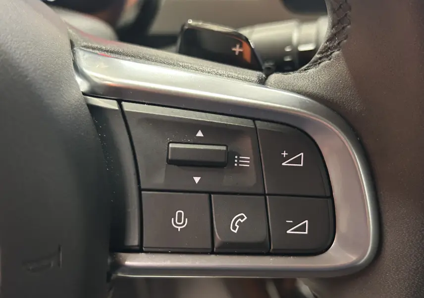 Gros plan sur les commandes au volant du FIAT 600 Hybrid 2024, boutons de volume et appels téléphoniques visibles.