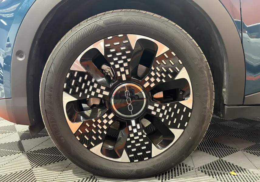 Gros plan sur la roue avant gauche d'une FIAT 600 Hybrid 2024 bleu, avec jante noire et argentée au design moderne.