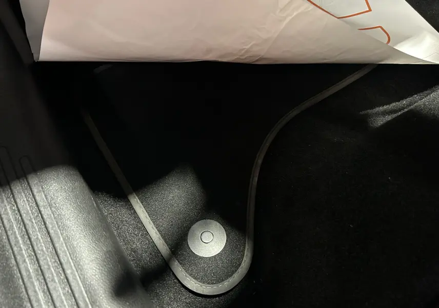 Détail du tapis de sol noir avec fixation circulaire dans l'habitacle d'une FIAT 600 Hybrid 2024 bleu.