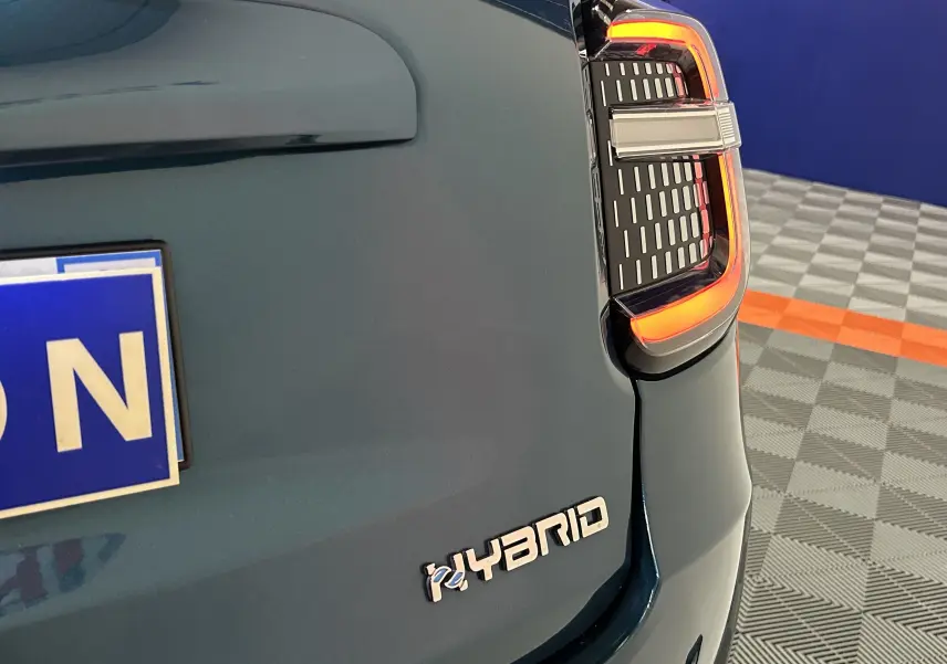 Gros plan sur le coin arrière droit bleu d'une FIAT 600 Hybrid 2024, mettant en valeur le feu arrière LED et le badge Hybrid.