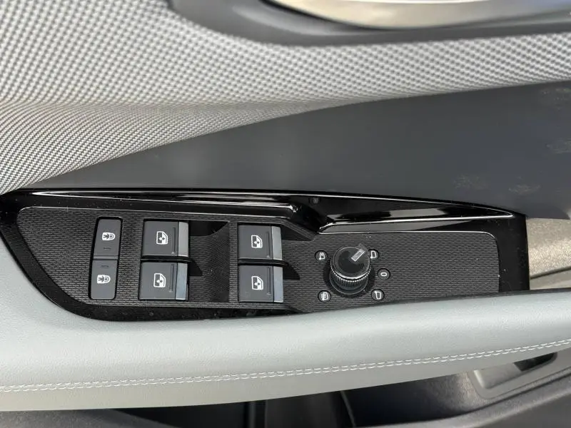 Gros plan sur les commandes des vitres et rétroviseurs côté conducteur de l'Audi Q3 2026 finition S line en Noir Mythique métallisé.