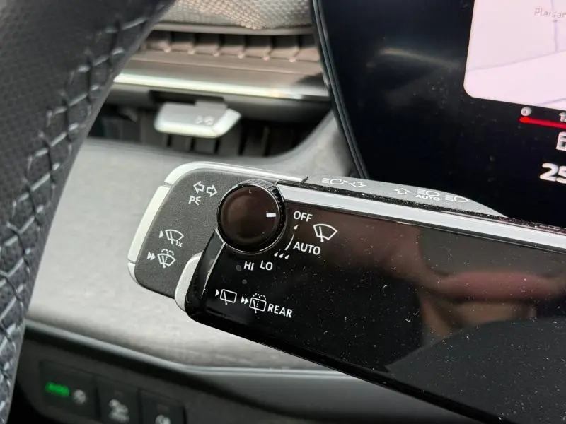 Gros plan sur la commande de l'essuie-glace du tableau de bord d'un Audi Q3 2026 noir métallisé, version S line.