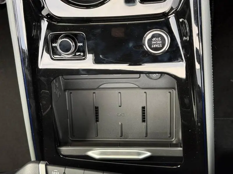 Gros plan sur la console centrale noire brillante de l'Audi Q3 2.0 TDI 150ch S line avec bouton start/stop et molette multimédia.