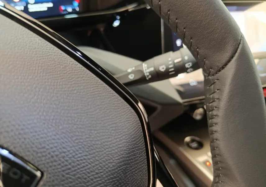 Gros plan sur le volant cuir gris foncé et la commande de clignotant de la Peugeot 308 BlueHDi 2026.
