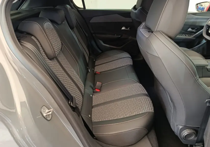 Vue intérieure côté gauche montrant la banquette arrière bi-matière grise et noire du Peugeot 308 BlueHDi 130 Allure 2026.