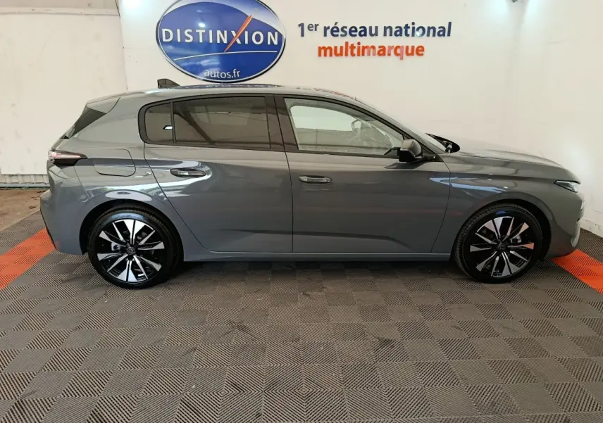 Profil droit de la Peugeot 308 BlueHDi 130 gris foncé 2026 avec jantes noires et détails chromés visibles.