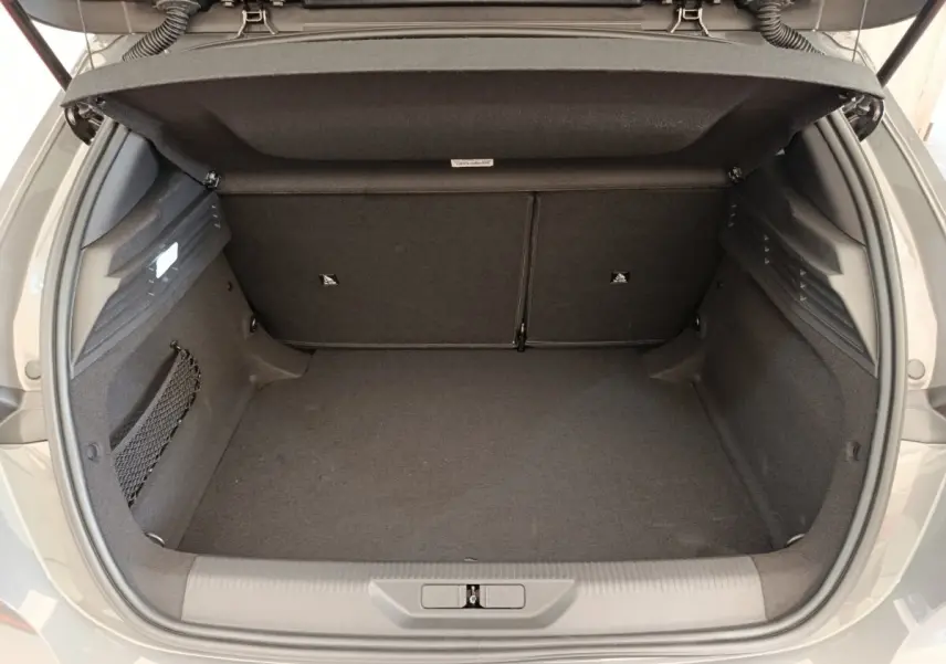 Coffre ouvert d’une Peugeot 308 gris foncé, vue arrière montrant l’espace de chargement et la banquette rabattable.