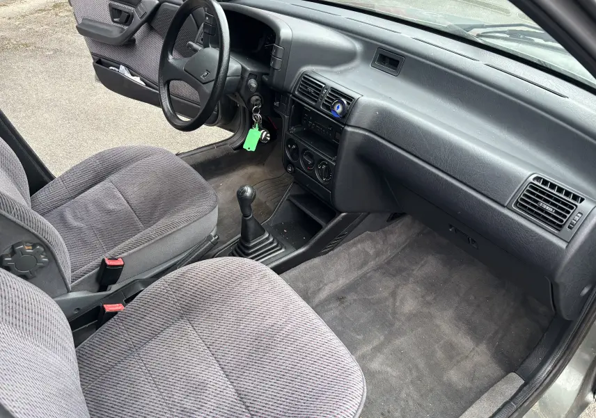 Intérieur avant droit d'une Citroën ZX 1.6i gris de 1992 avec sièges tissu et boîte manuelle à 5 vitesses.