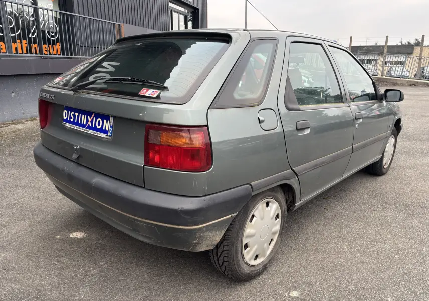 Vue 3/4 arrière droite d'une Citroën ZX gris 1992 avec hayon et feux arrière rectangulaires rouges et orange.