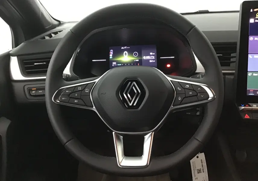 Volant multifonction noir avec logo Renault, tableau de bord numérique et partie centrale de la planche de bord du Renault Captur 2025.