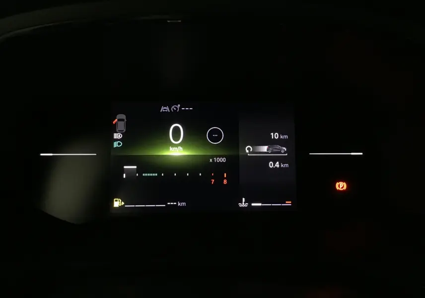Tableau de bord numérique du Renault Captur 2025 affichant la vitesse à 0 km/h et indicateurs lumineux en ambiance sombre.