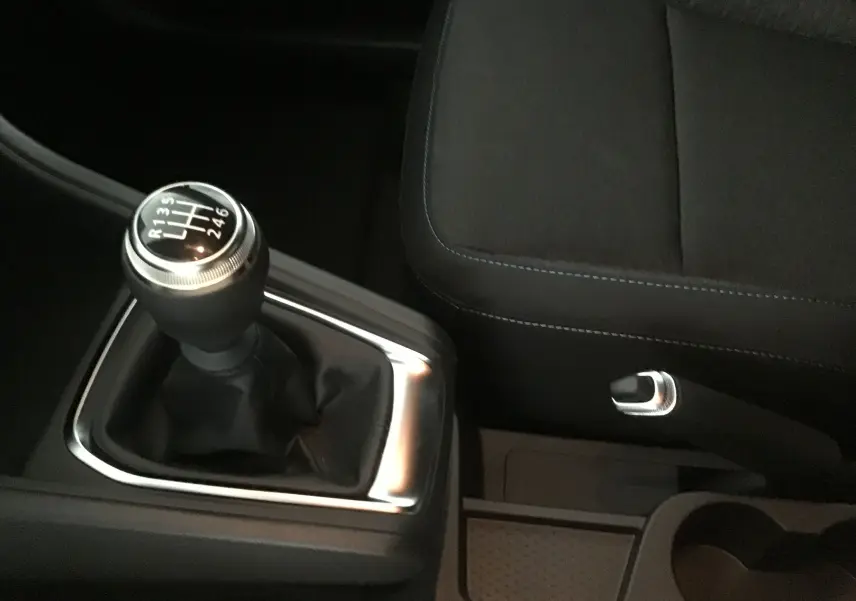 Le levier de vitesses manuel et le frein à main du Renault Captur gris rafale/ noir vus de près dans l'habitacle.