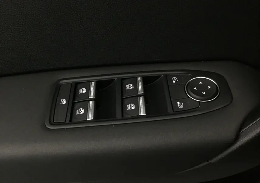 Panneau de commandes des vitres et rétroviseurs électriques sur la portière intérieure noire du Renault Captur 2025 gris rafale.